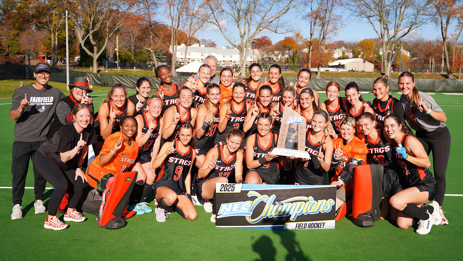A group photo of the women's field hockey team, showcasing players in uniforms, standing together with smiles.