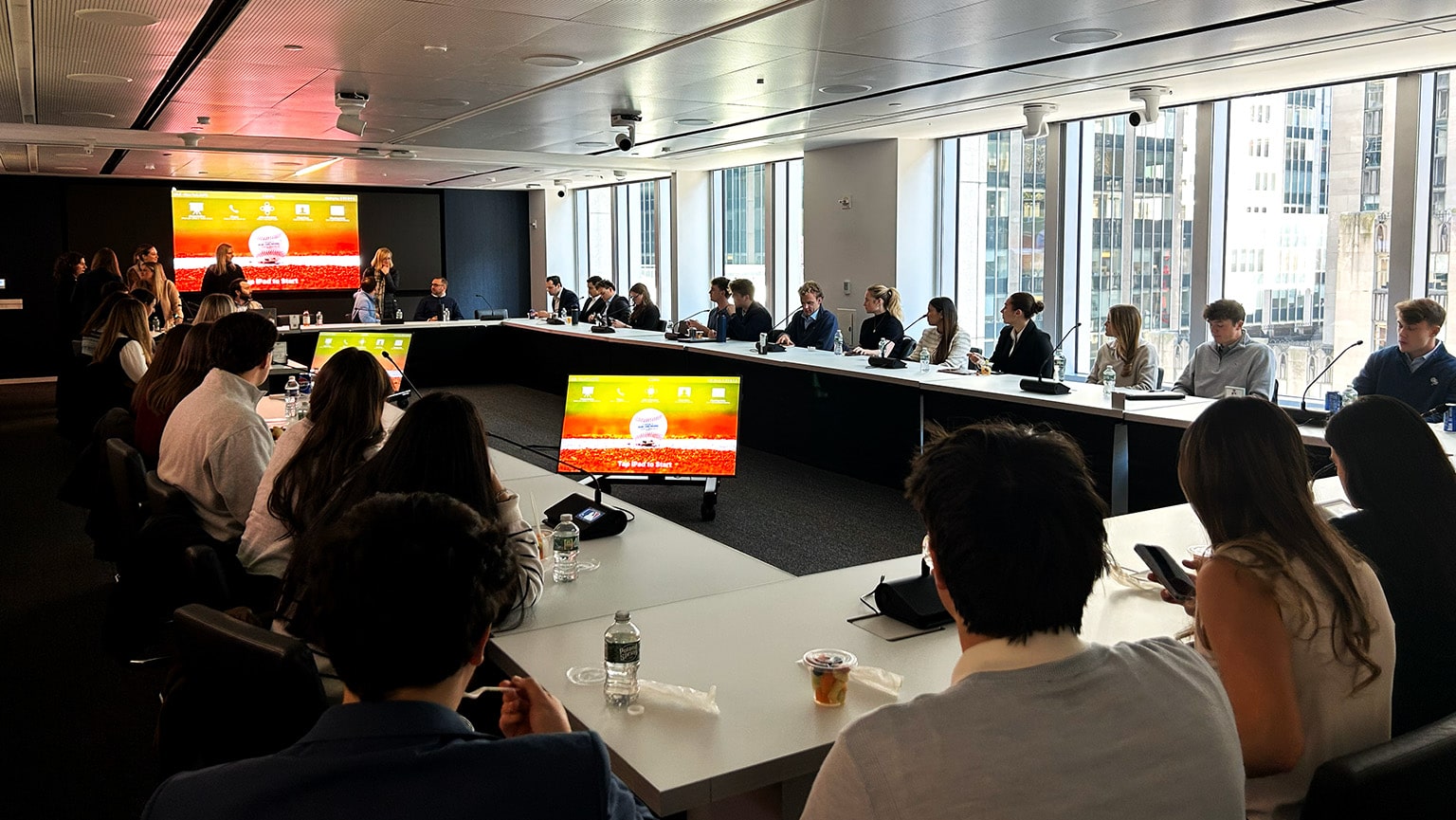 Fairfield students sitting at a large, rectangular meeting table as they participate in a presentation.