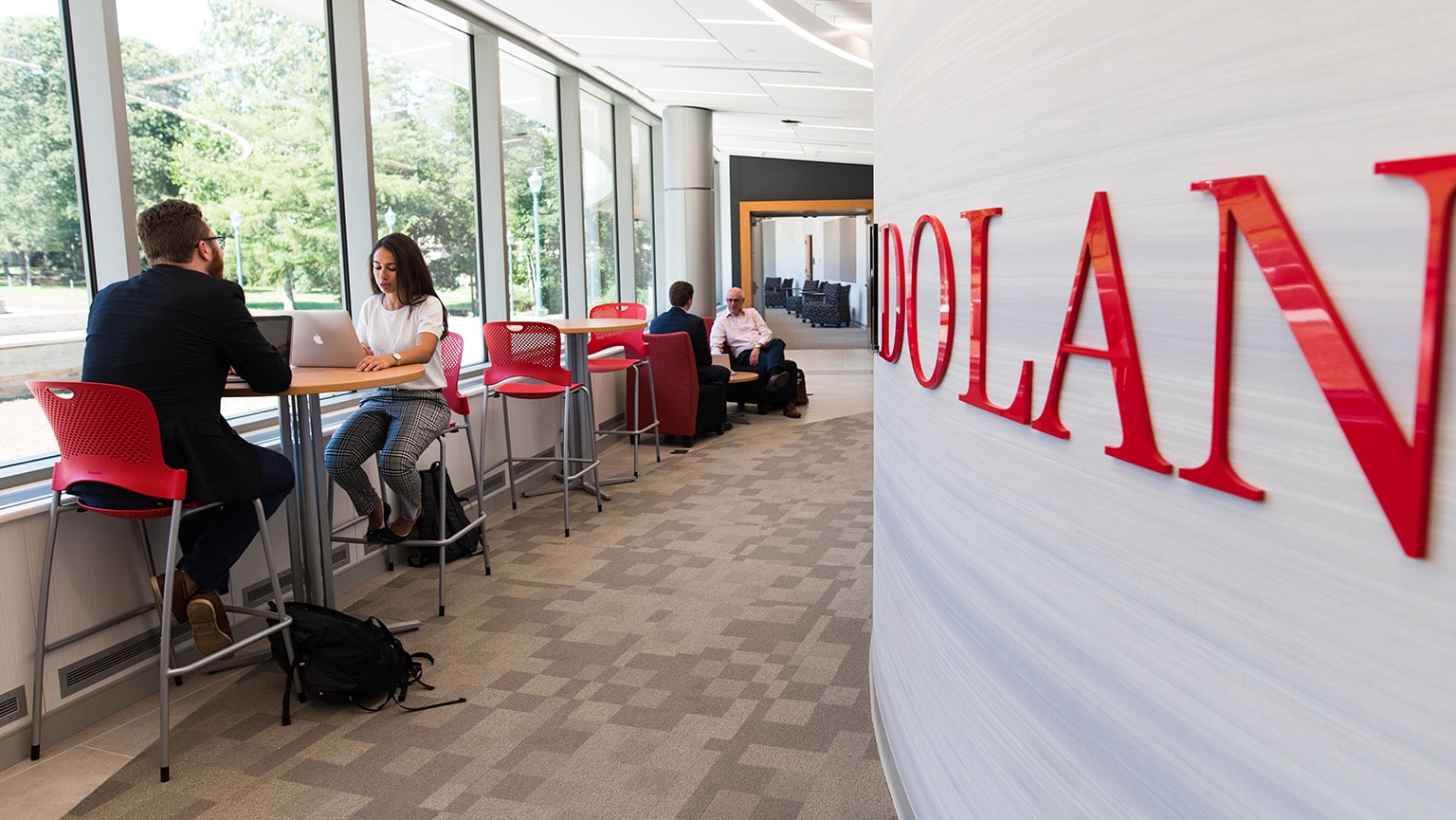 Students sitting and working in the study lounge area of the Dolan School of Business.