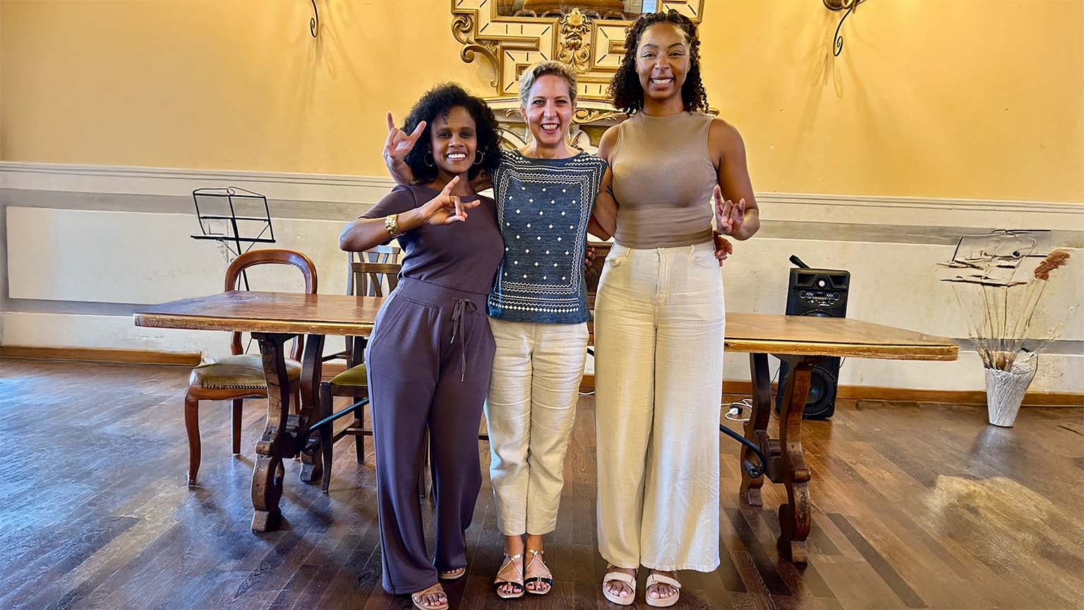 Image of three friends striking a pose for a fun photo in a stylish indoor space.