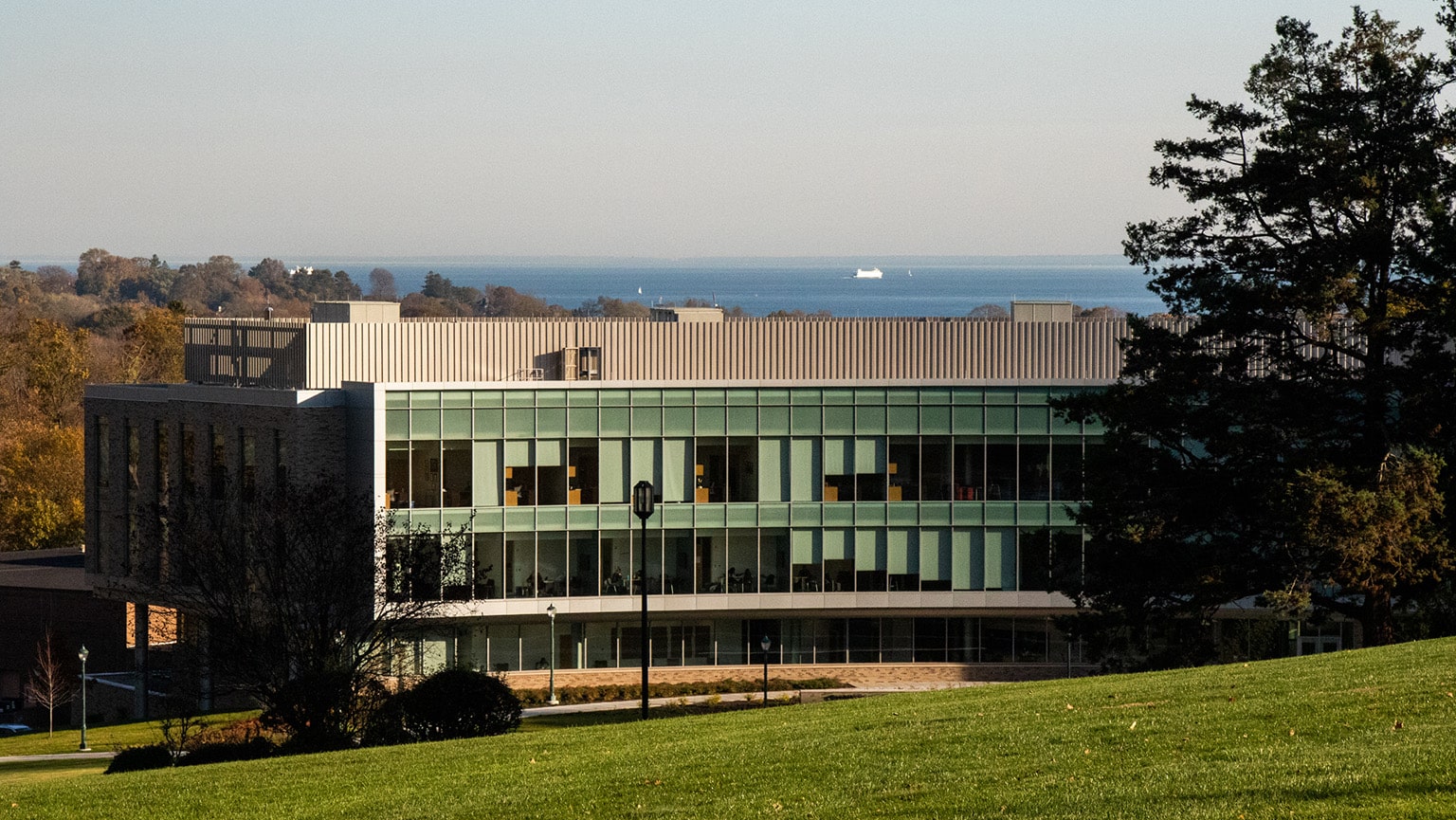Exterior shot of the glass-window Charles F. Dolan School of Business right before sunset.