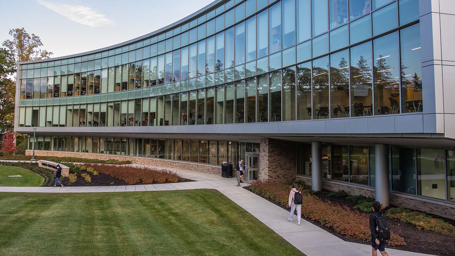 A building surrounded by vibrant trees and grassy areas, offering a peaceful natural setting.