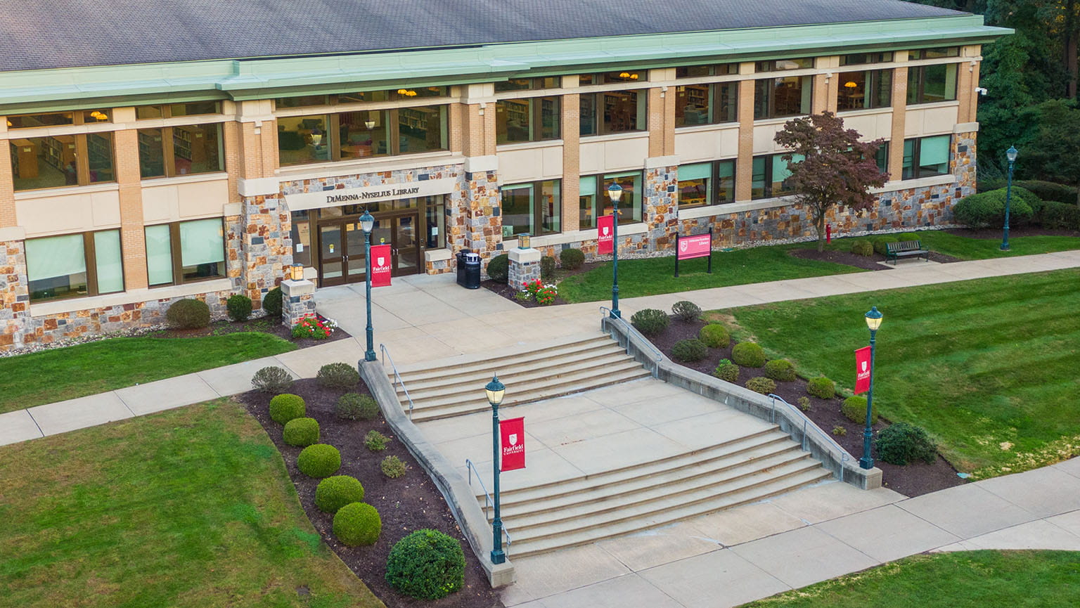 Aerial view of Fairfield's brick-and-glass DiMenna-Nyselius Library, with its sprawling stone steps and manicured landscaping.