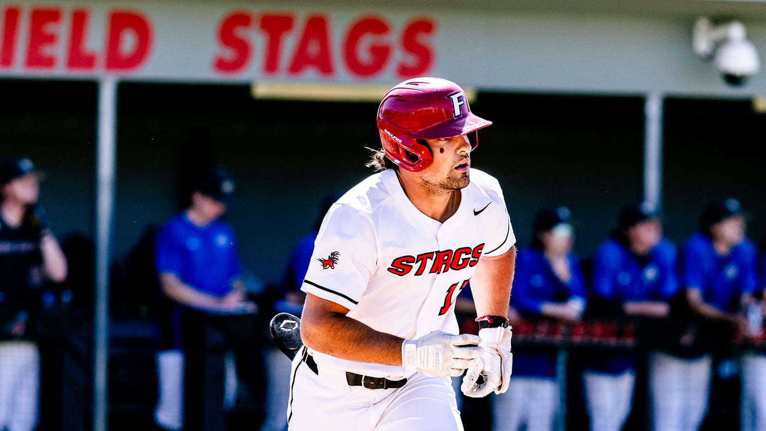 Fairfield Baseball student-athlete Matthew Bucciero ’26, reigning MAAC Player of the Year, in a white uniform jogging to first base.