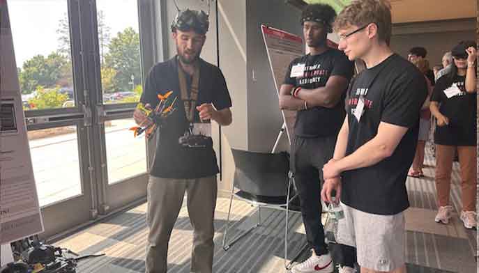 A diverse group of people gathered around a showcase featuring various robots on display.