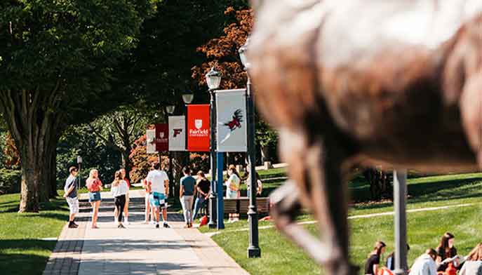 Student walking down path with Stat Statue in foreground