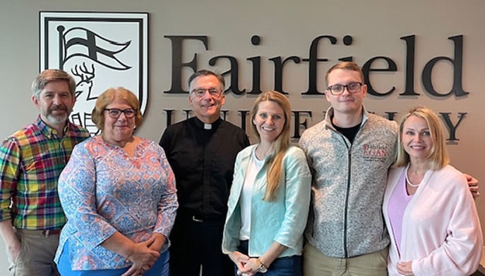 Rev. Kevin O'Brien, S.J., poses with faculty and staff at Austin, TX campus.