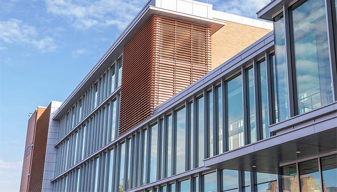 Image of the Egan Nursing School showcases a contemporary design with a large glass wall and an expansive window.