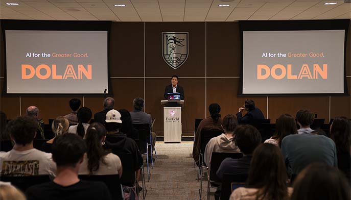 Image of a man standing at a podium, addressing a crowd during a presentation
