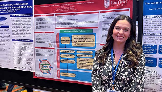 Image of a woman poses next to an informative poster, highlighting details with a friendly expression.