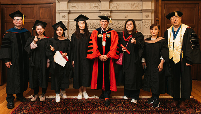 A diverse group of graduates wearing caps and gowns, celebrating their academic achievements together.