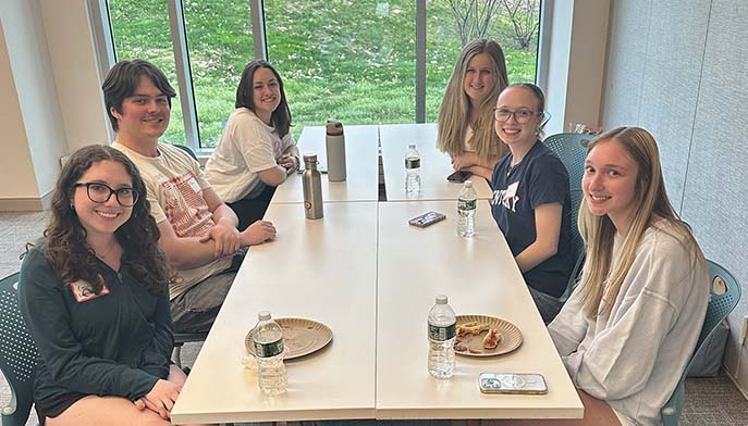 Image of students sitting around a table during a lively discussion