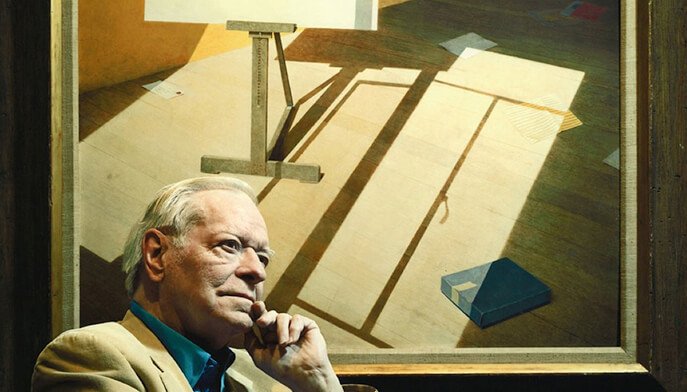 A man is seated before a painting, with a lamp casting warm light, enhancing the viewing experience of the artwork.