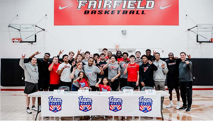 The team gathers for a cheerful photo in front of a large banner, highlighting their spirit and teamwork.