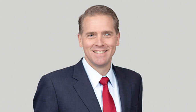 Headshot of Scott Jennings sitting in front of beige wall.