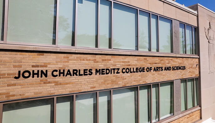 Front facade of the John Charles Meditz College of Arts and Sciences, highlighting its architectural features and inviting atmosphere.  