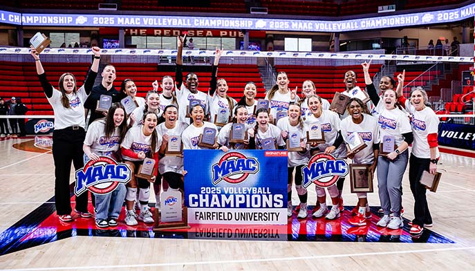 The women's volleyball team proudly holds up their championship banner, celebrating their victory together.