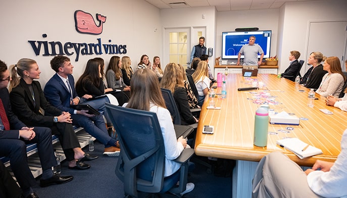 Fairfield students sitting in a conference room at Vineyard Vines HQ (Stamford) listening to a brand presentation.