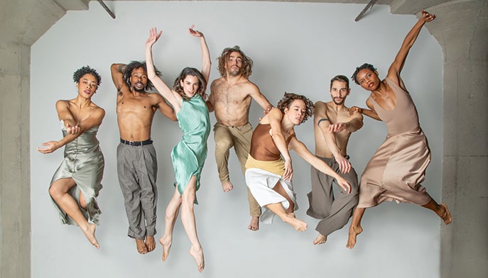 Seven-performer group (BODYTRAFFIC) suspended in the air in various poses.