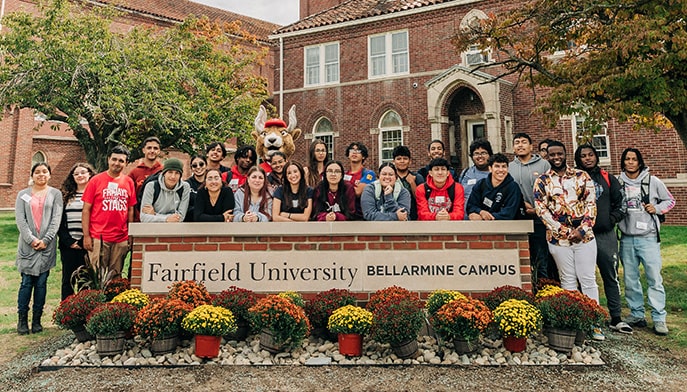 Members of the first graduating class of Fairfield Bellarmine standing proudly behind the brick campus sign.