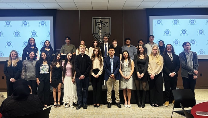 Newly-inducted members of the first-generation student Tri-Alpha honor society posing proudly.