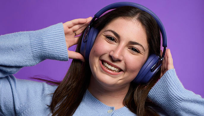 Fairfield alumna wearing a pair of Bose over-the-ear headphones.