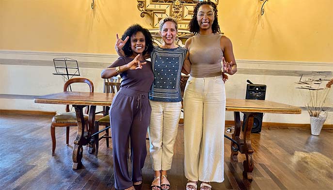 Image of three friends striking a pose for a fun photo in a stylish indoor space.