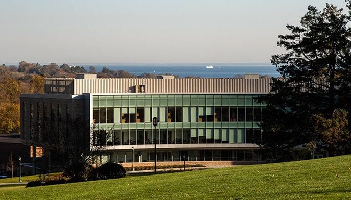 Exterior shot of the glass-window Charles F. Dolan School of Business right before sunset.