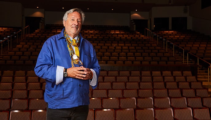 Portrait of Philip I. Eliasoph standing in an empty venue seating area prior to a lecture.