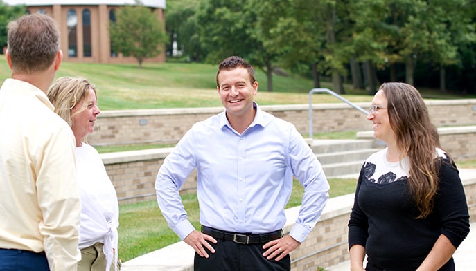 Fairfield Executive DBA candidates standing and having a discussion outside the School of Business building.