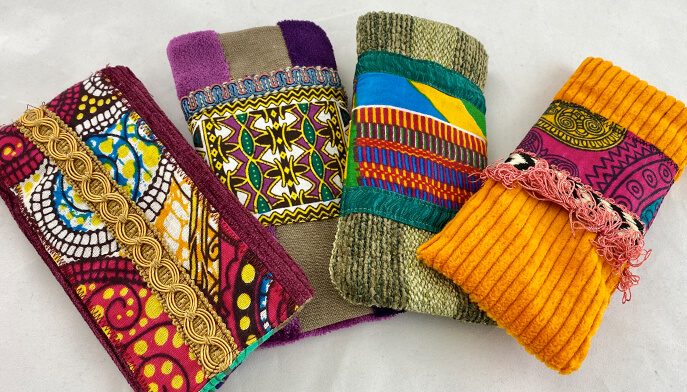 A collection of four colorful purses, each showcasing distinct and vibrant patterns, displayed side by side.