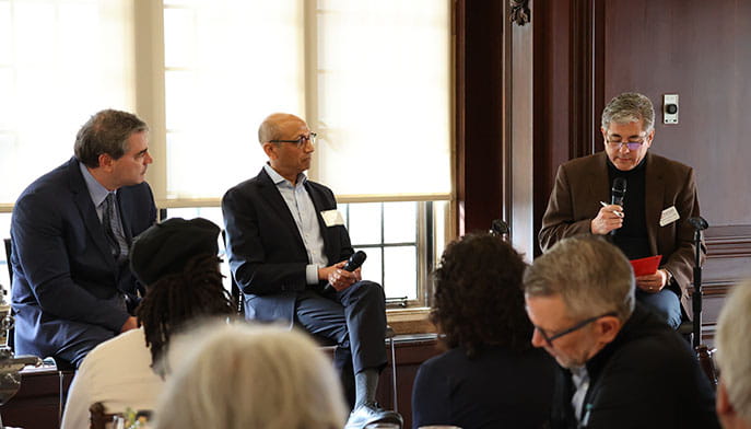 Colloquium speakers sitting at the front of a brightly-lit windowed room while discussing the future of manufacturing in CT.