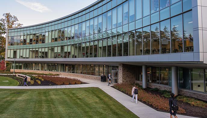 A building surrounded by vibrant trees and grassy areas, offering a peaceful natural setting.