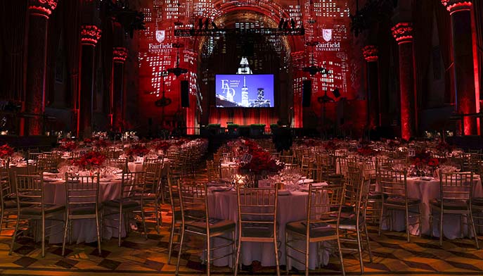 A spacious dining room with neatly arranged tables and chairs ready for a dinner gathering.