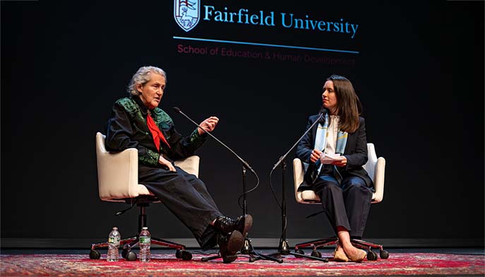Two speakers in conversation on a stage at Fairfield University’s School of Education and Human Development event.