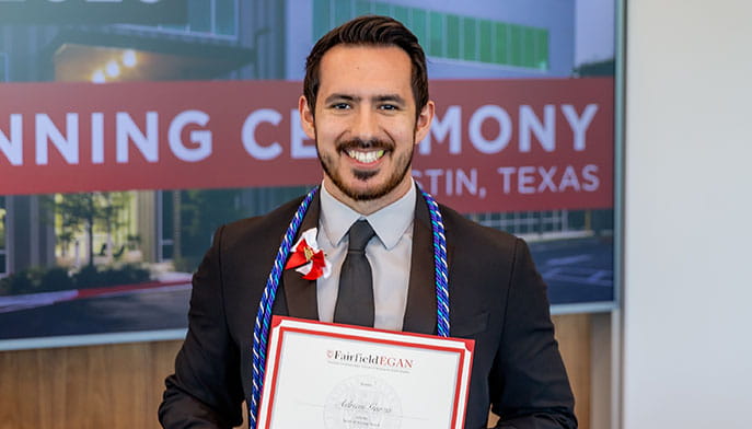 A nursing alumnus with his 'Spirit of Nursing' award, after receiving it at the annual Egan pinning ceremony.