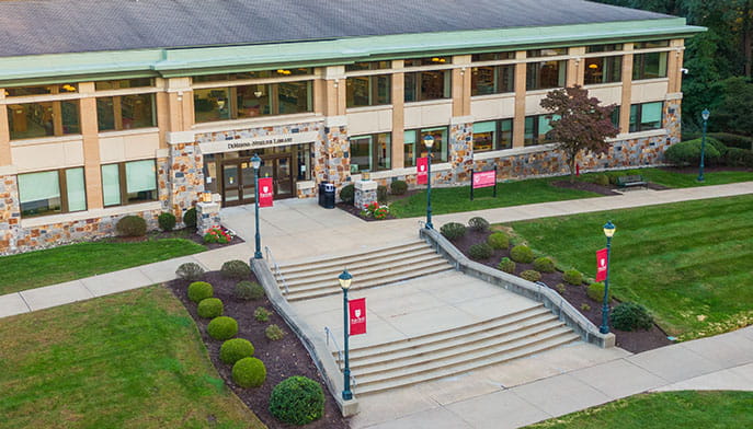 Aerial view of Fairfield's brick-and-glass DiMenna-Nyselius Library, with its sprawling stone steps and manicured landscaping.