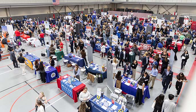 Attendees and recruiters engage in discussions at a lively job fair, showcasing various career opportunities.