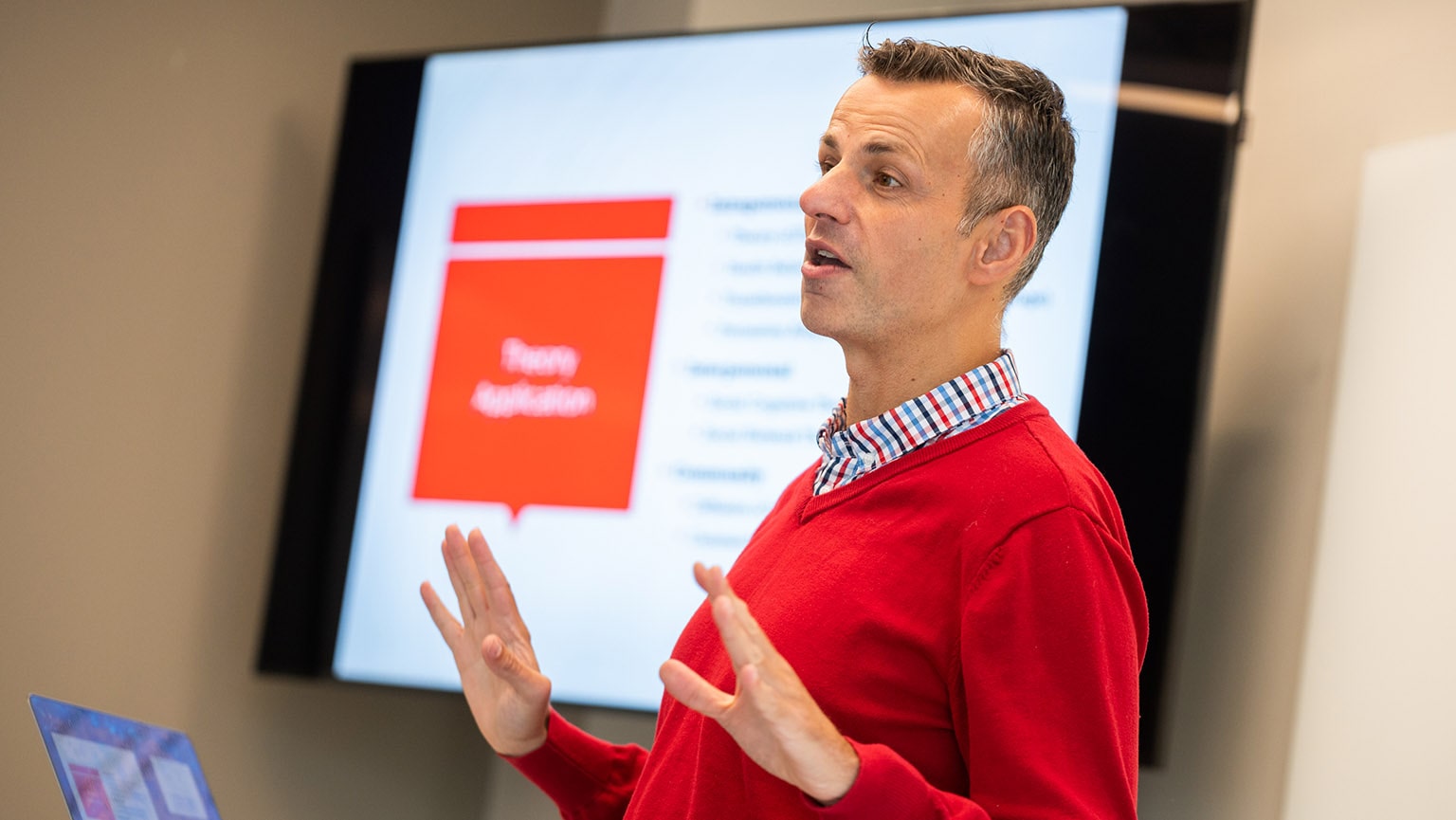 Fairfield Nursing professor giving a lecture in front of a powerpoint screen.