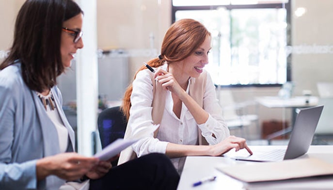 A business analyst discusses business processes with a colleague.