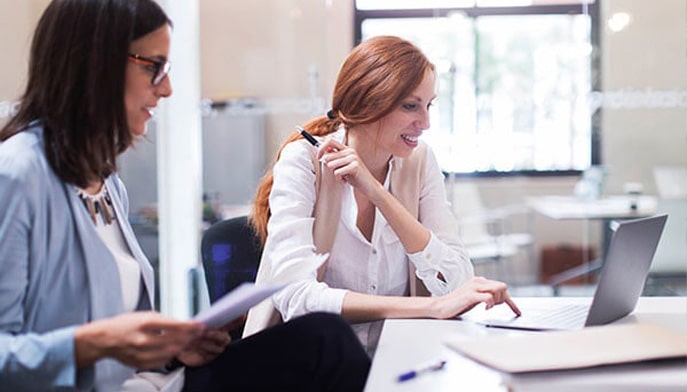 A business analyst discusses business processes with a colleague.