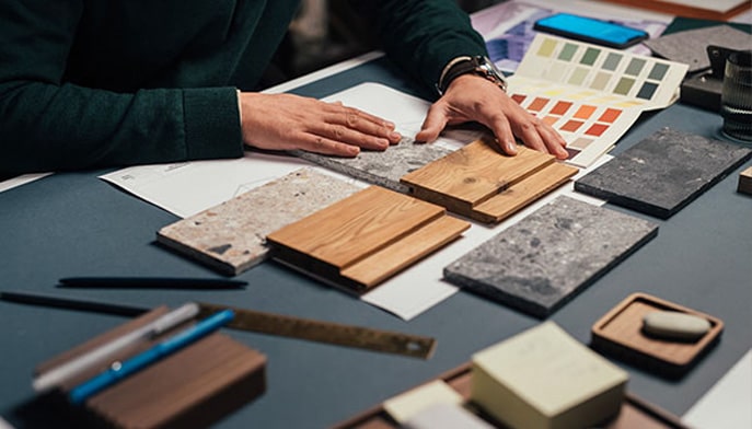 Interior Designer measuring and comparing flooring samples.