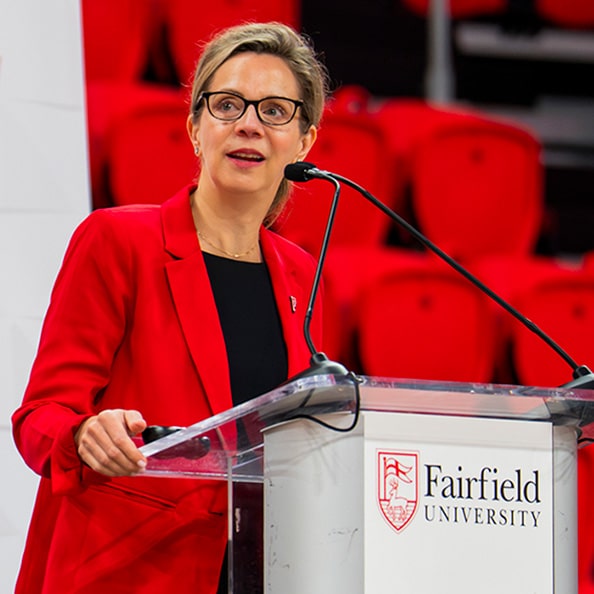 Provost Christine Siegel speaking about artificial intelligence (ai) at a Fairfield-branded podium.