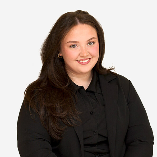 Marina Chiaro ’26 smiling with long dark hair wearing a black blazer and shirt, sits against a plain white background. Her expression conveys warmth and confidence.