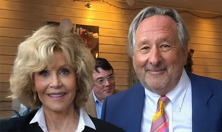 A man and woman are cheerfully smiling at the camera, capturing a joyful moment.