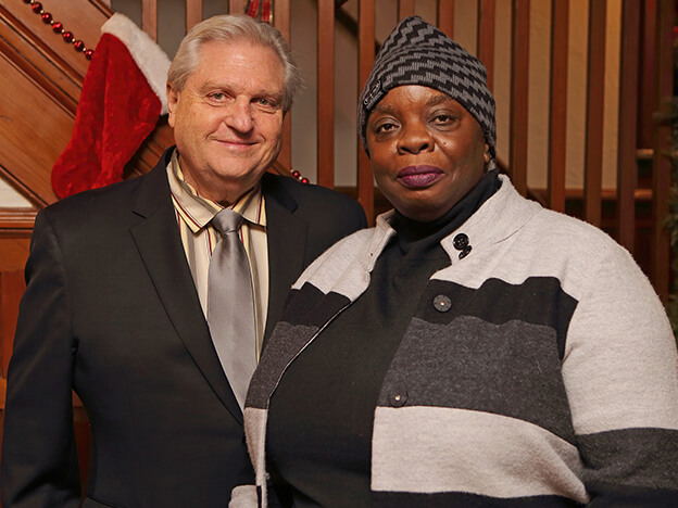 A man and a woman standing together, facing the camera with friendly expressions.