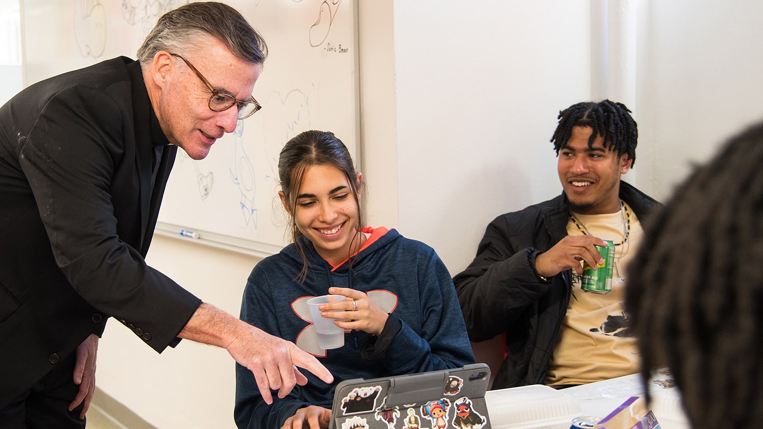 Rev. O'Brien, S.J. interacting with Fairfield Bellarmine students as they work in a group.