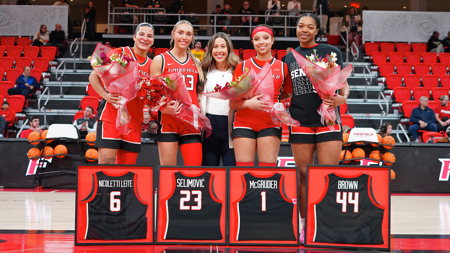 A group photo of the women's basketball team, showcasing their jerseys and team spirit with smiles.