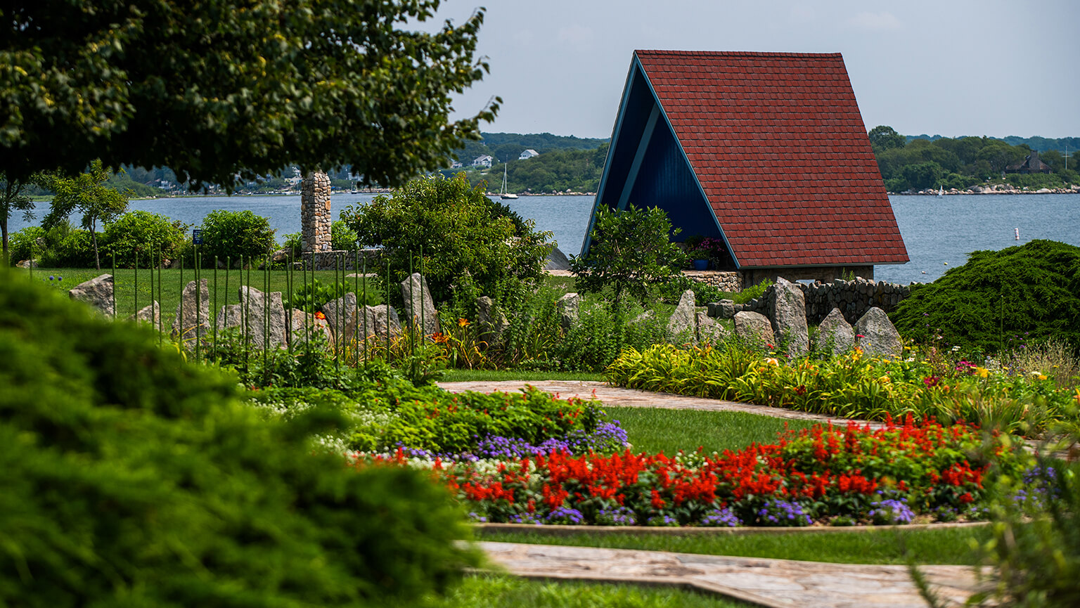 A quaint structure with a vibrant red roof, set in a serene environment.
