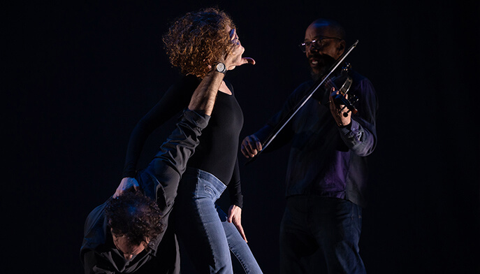 A man and woman engaged in a dynamic dance performance on stage, captivating the audience with their artistry.